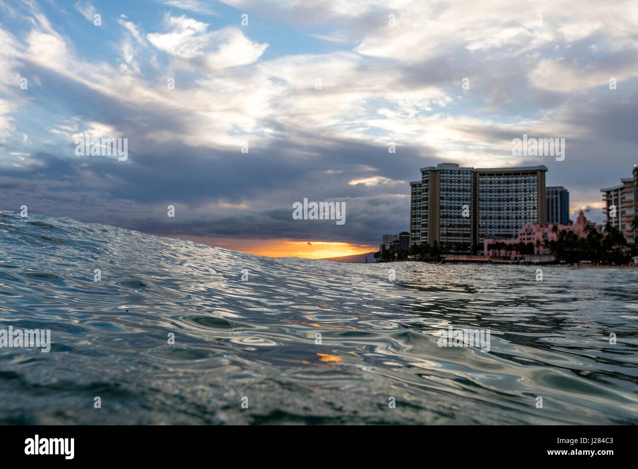 Sea against cloudy sky in city during sunset Stock Photo