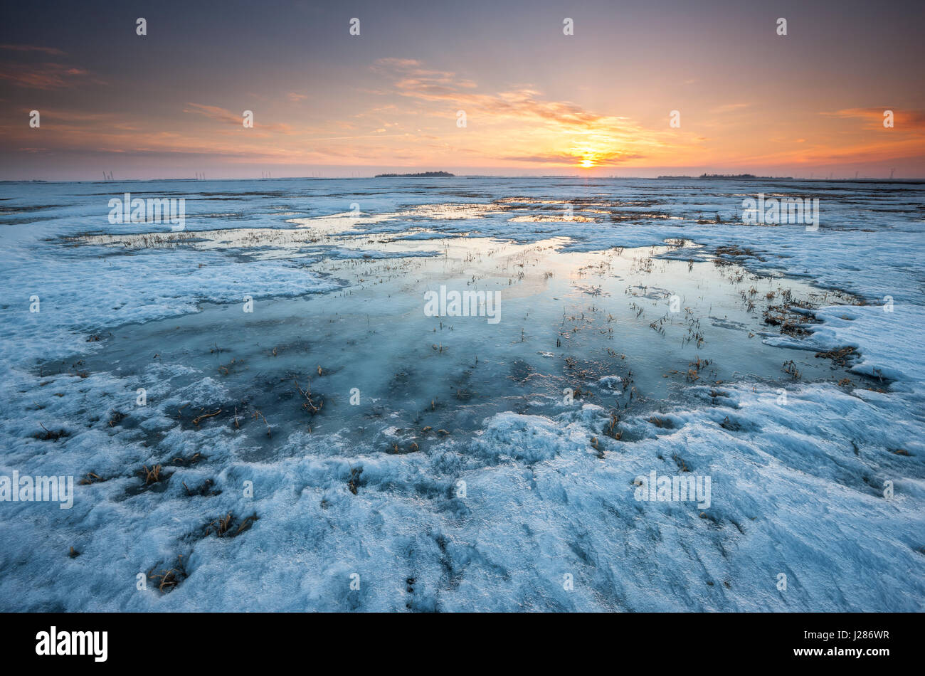 Sunset on frozen and snow covered fields in Manitoba, Canada Stock Photo