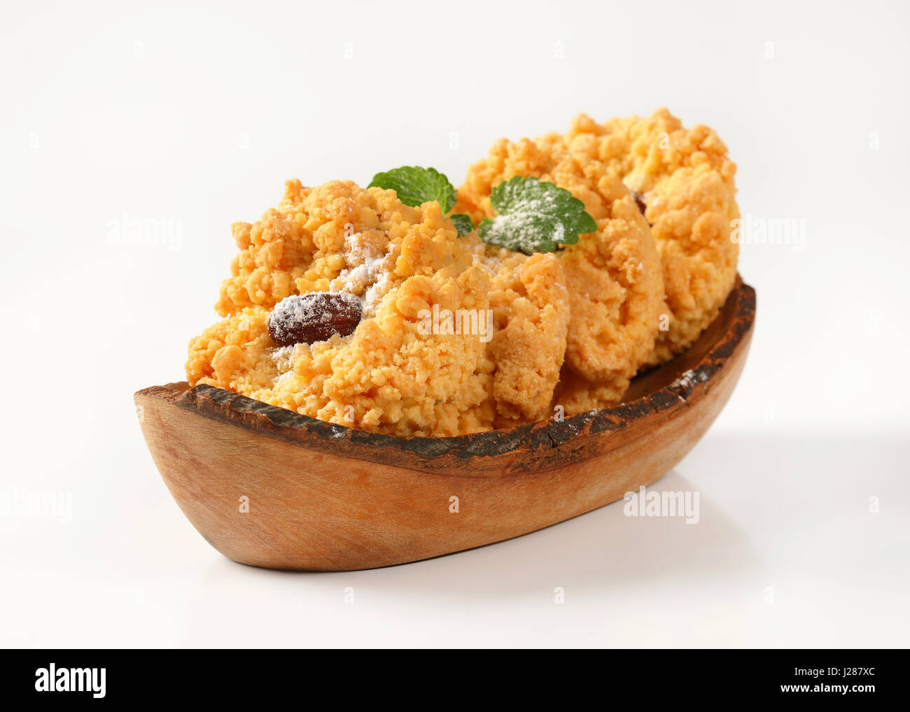 Almond crumb cookies in olive wood boat-shaped bowl Stock Photo