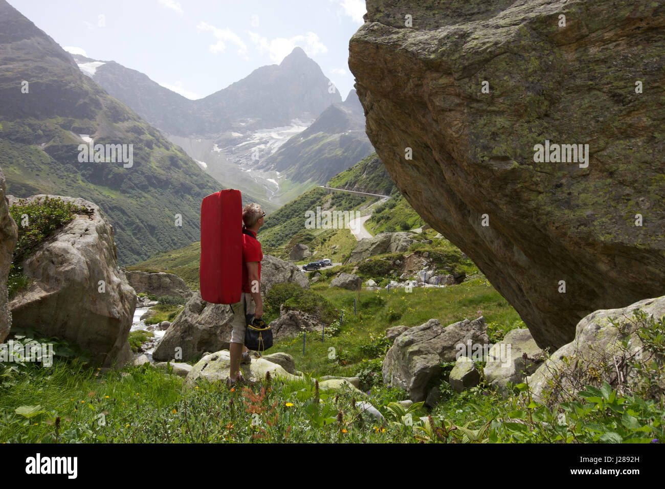 A rock climber examines some boulders in Susten Pass, Switzerland Stock Photo