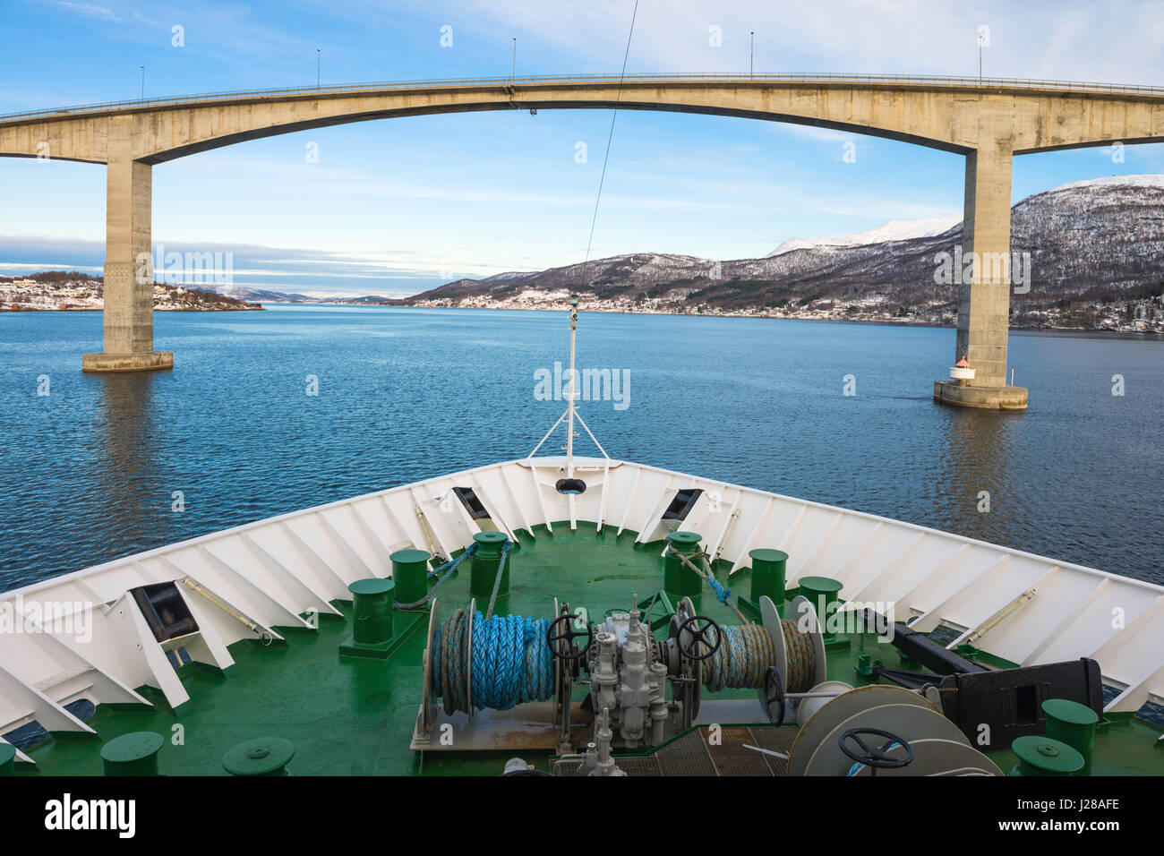 Hurtigruten Coastal Express cruise ship 'Nordnorge' approaches the Gisund bridge to Senja Island at Finnsnes, Troms County, Norway. Stock Photo