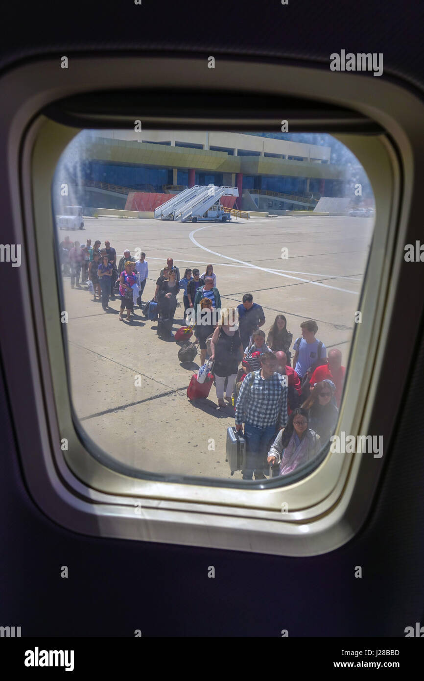 People queueing to board aircraft seen through window Stock Photo