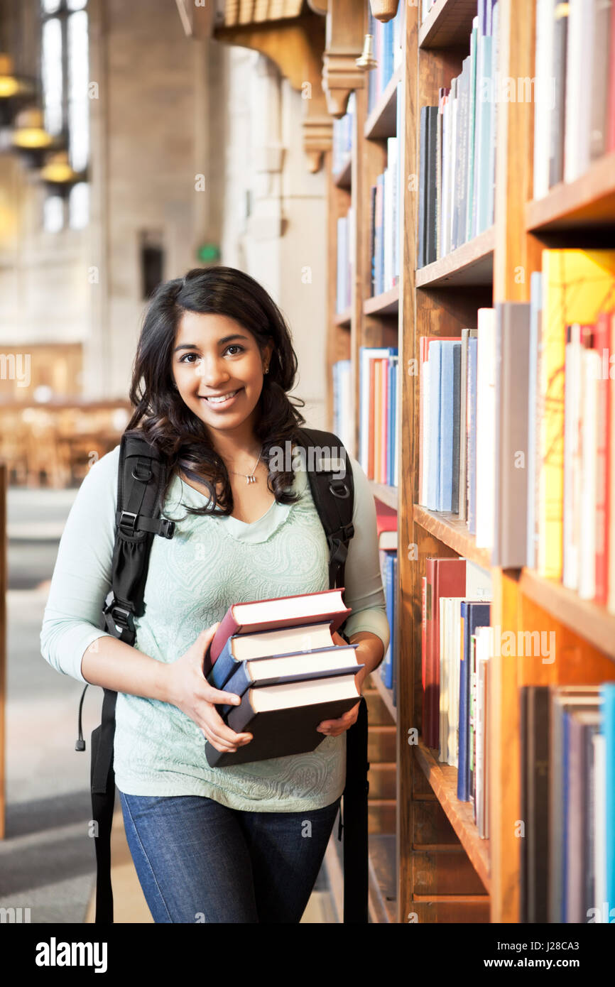 A shot of an asian student holding books at the library Stock Photo - Alamy
