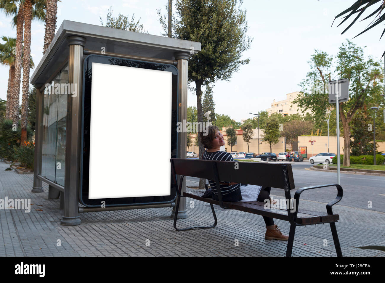 Blank billboard mock up, with a young woman sitting in a bench Stock Photo