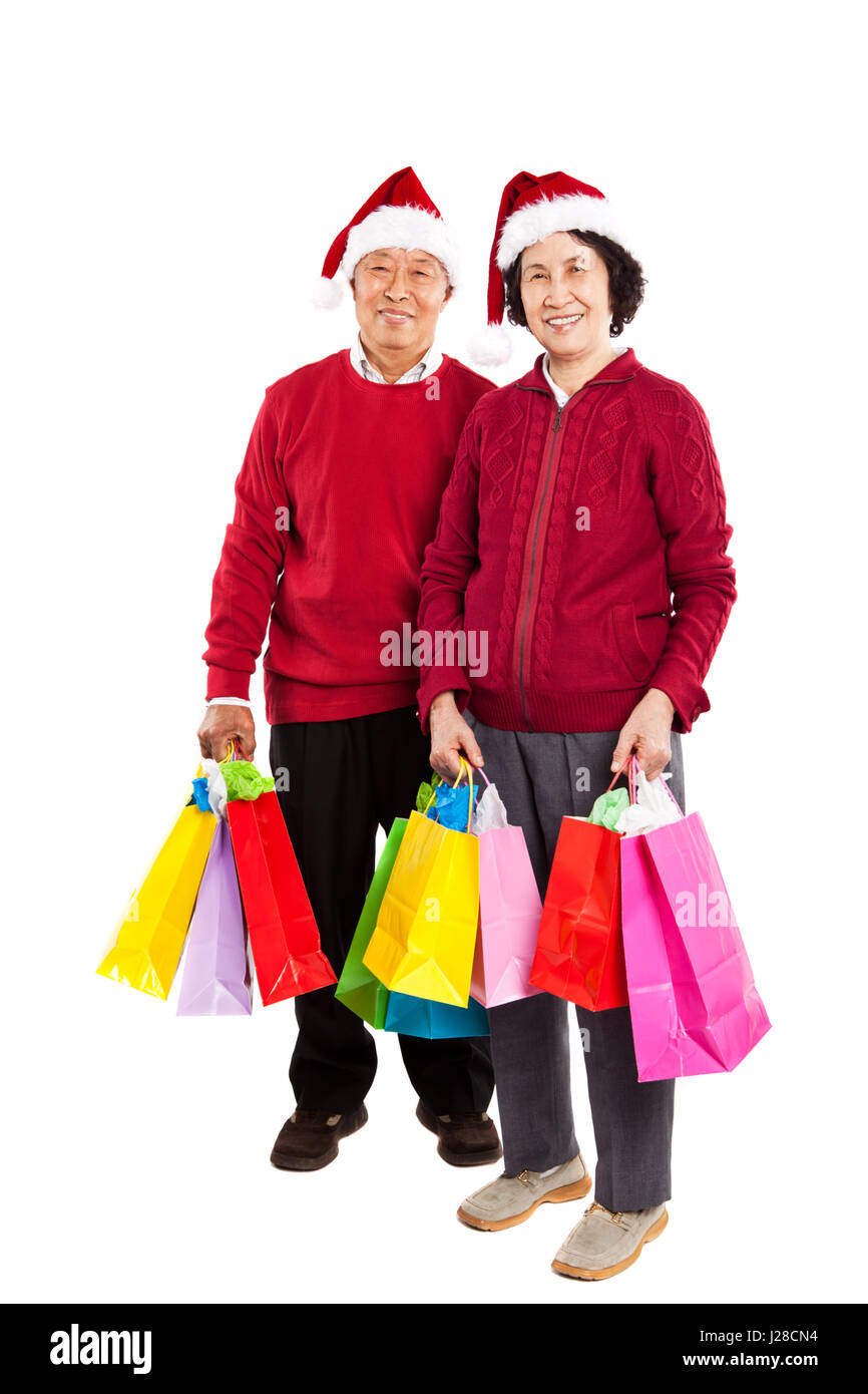 A shot of senior Asian couple carrying shopping bags celebrating Christmas Stock Photo