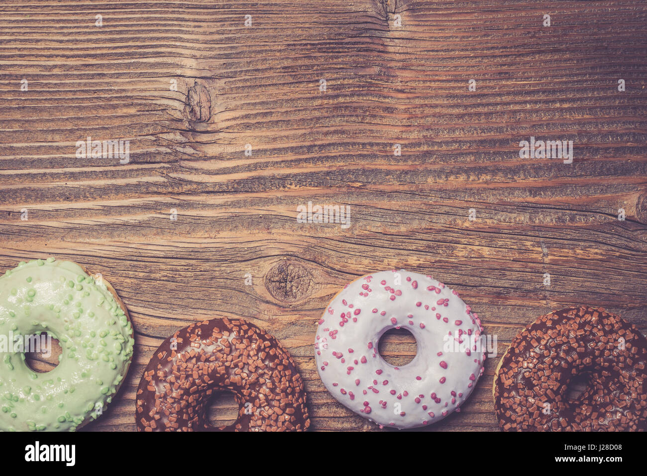 Colorful donuts on wooden table Stock Photo