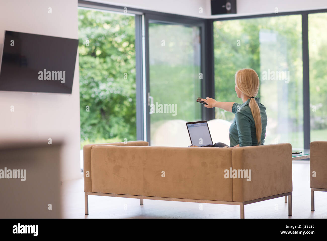 Young woman using her laptop computer in her luxury modern home ...