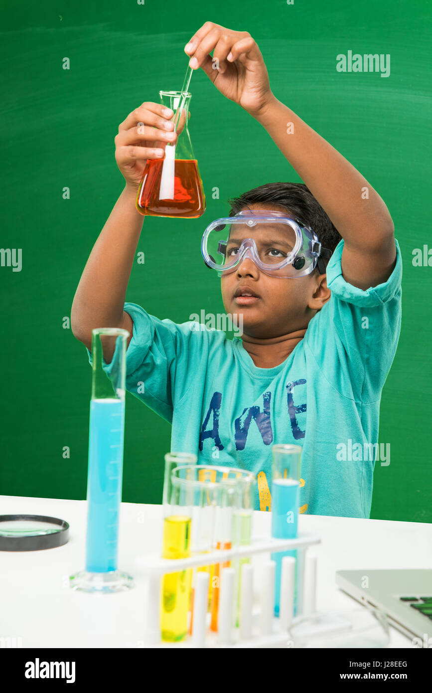 cute indian kids doing science experiment in chemistry lab or biology