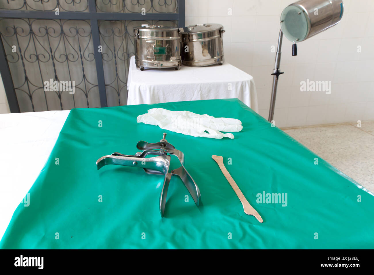 Colposcop, spatula and Medical gloves on a clean green blanket