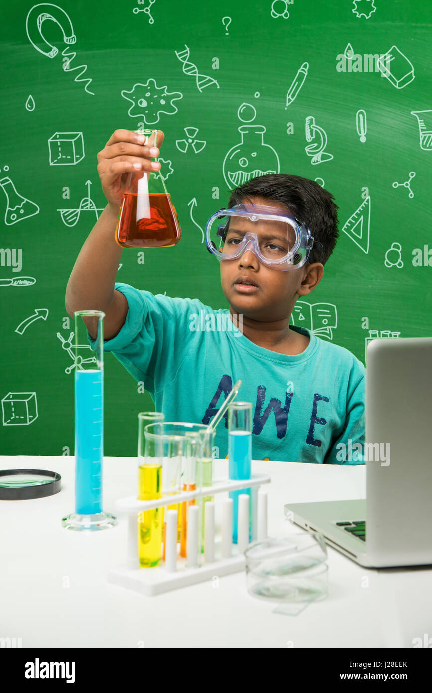 cute indian kids doing science experiment in chemistry lab or biology