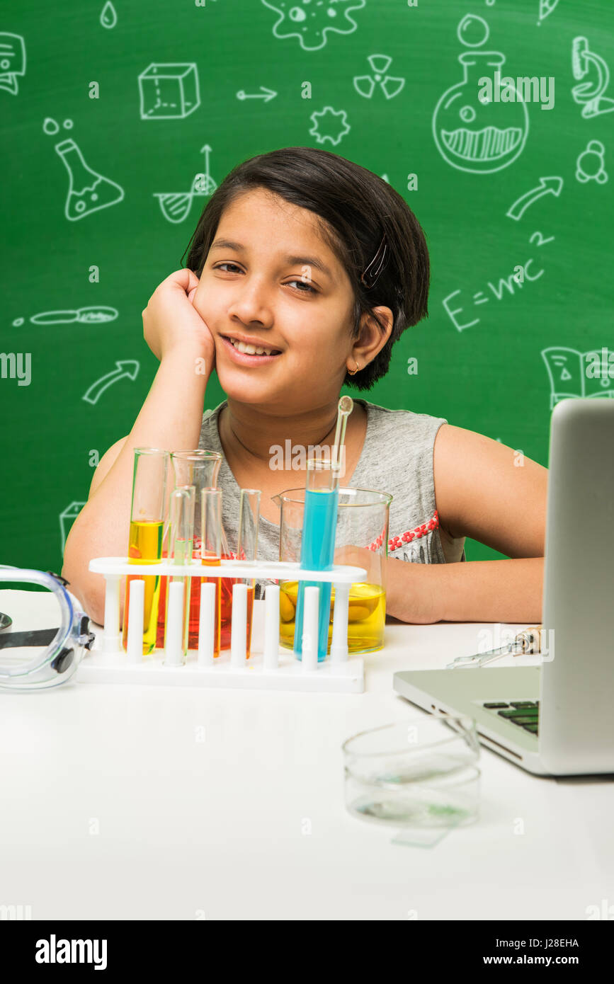 cute indian kids doing science experiment in chemistry lab or biology
