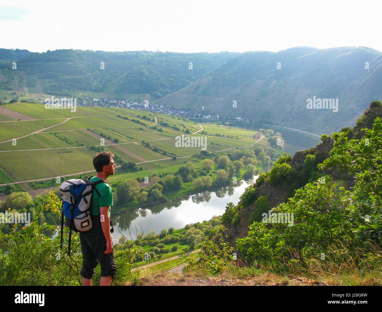 Germany, Rhineland-Palatinate, Bremm, hiker looking over river and vineyards on the Mosel steep path Stock Photo