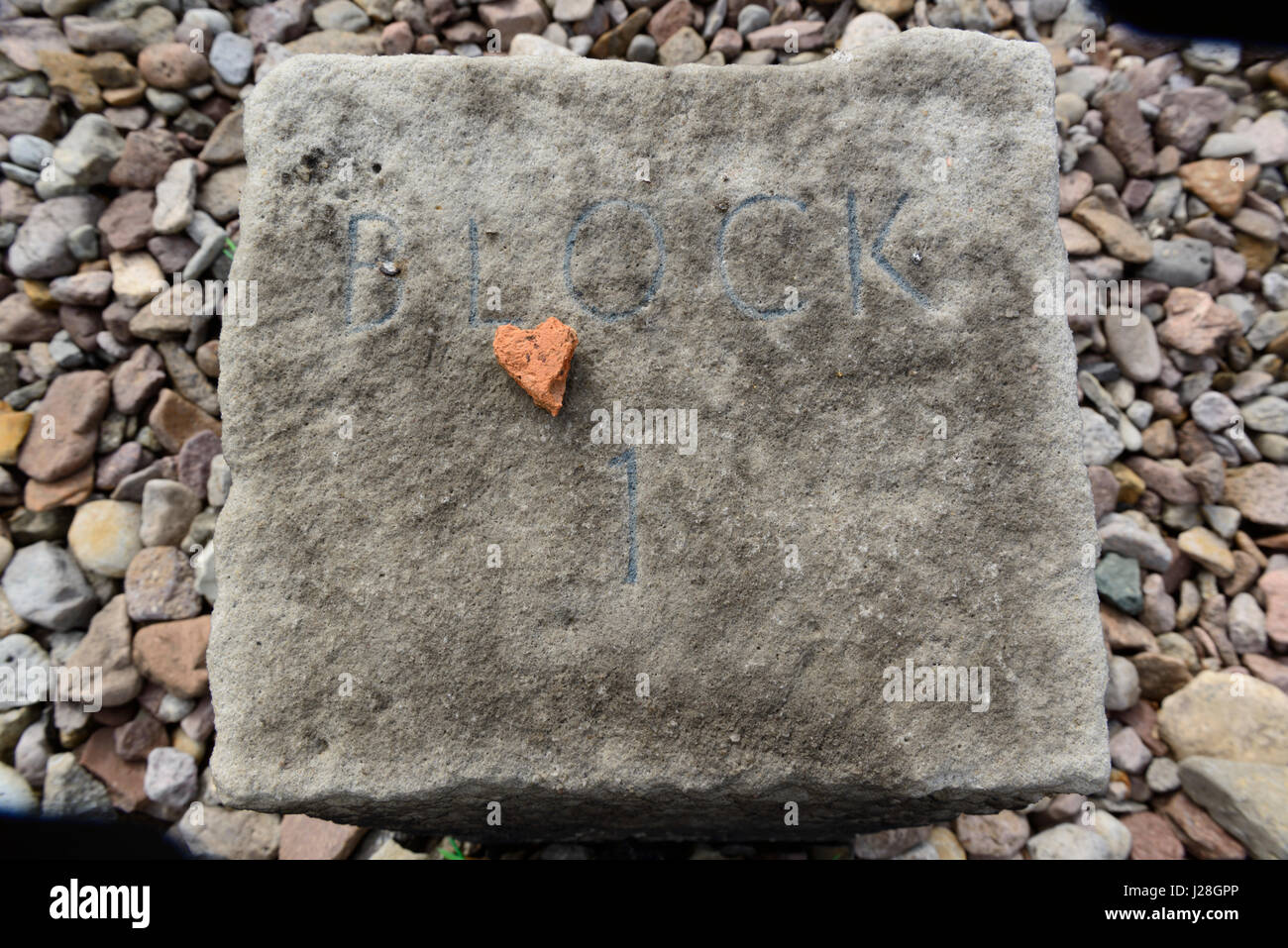 Small stone in the shape of a heart laid down on the place of block 1 in Buchenwald concentration camp memorial near Weimar, Germany. Stock Photo