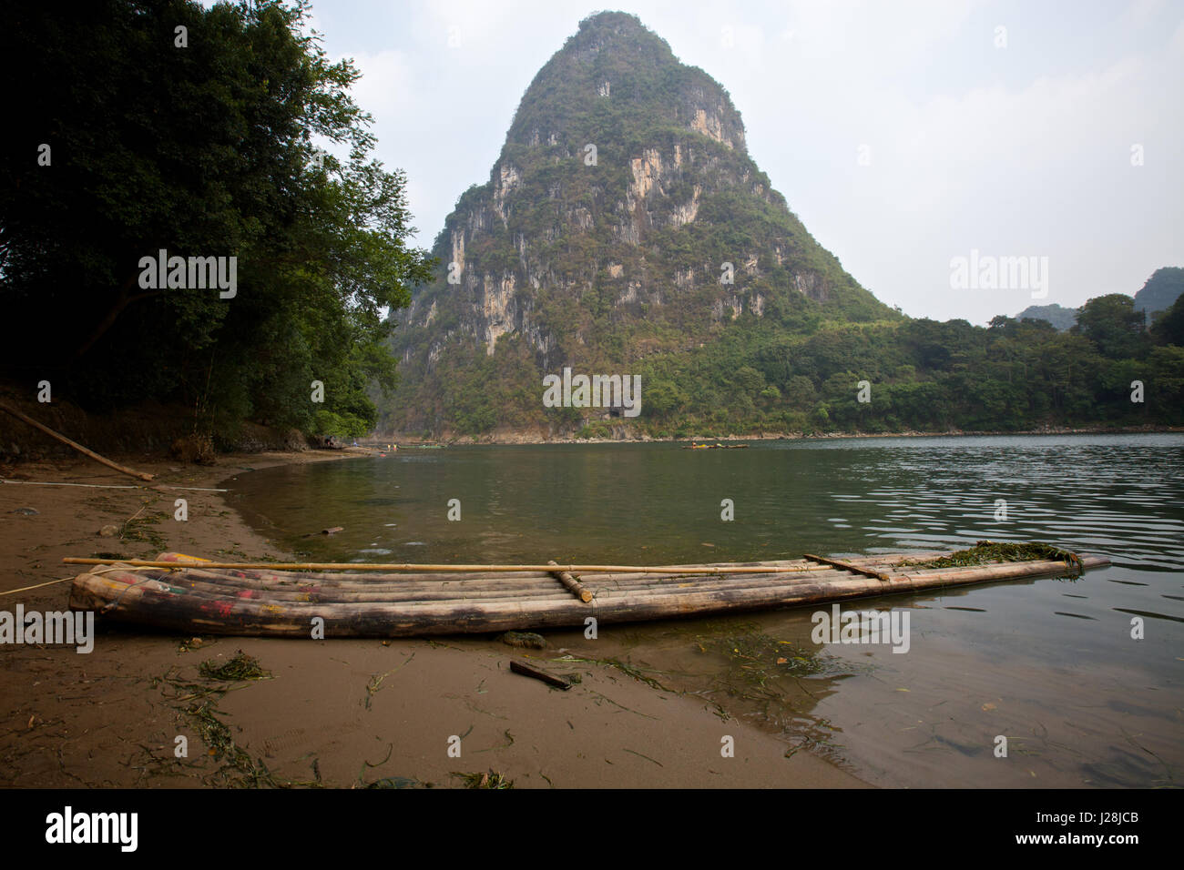 A traditional bamboo raft on the shore a river in Yangshou, China Stock Photo