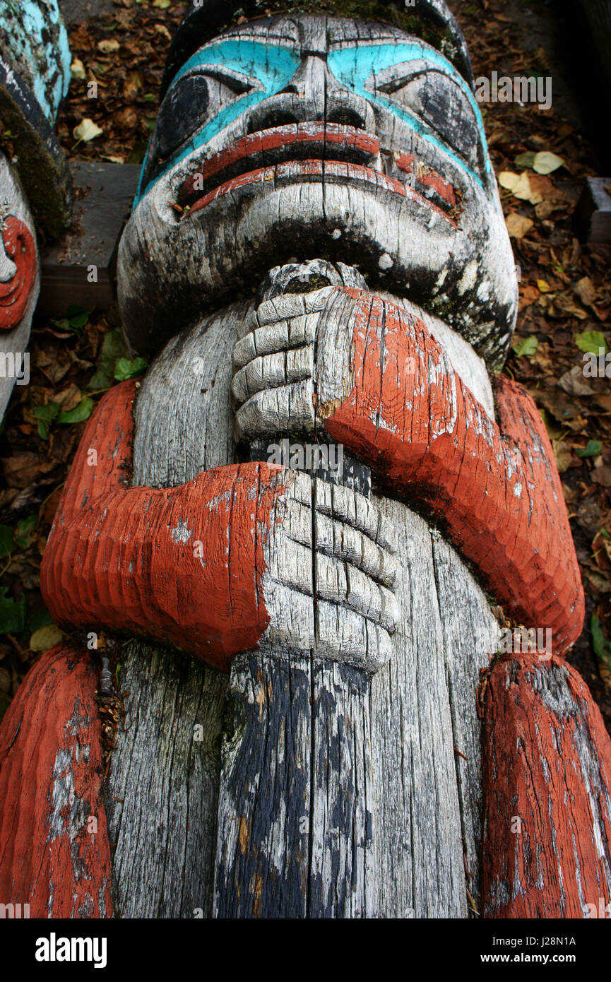 Human  carving on Totem pole laying on the ground, Tlingit Indians, Haines, Alaska Stock Photo