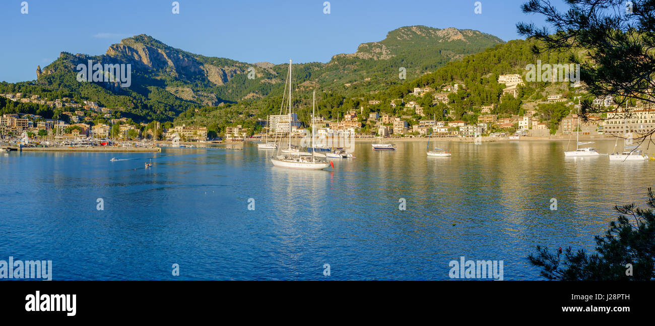 Panoramic view of boats moored in the bay at Port de Soller, Majorca, Spain, in the evening sunlight (21x9). Stock Photo