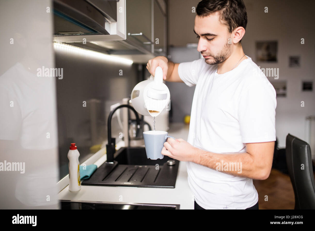 Man In Kitchen Pouring A Mug Of Hot Coffee From Glass Pot Having Breakfast Man In Kitchen Pouring A Mug Of Hot Coffee From Glass Pot Having Breakfast