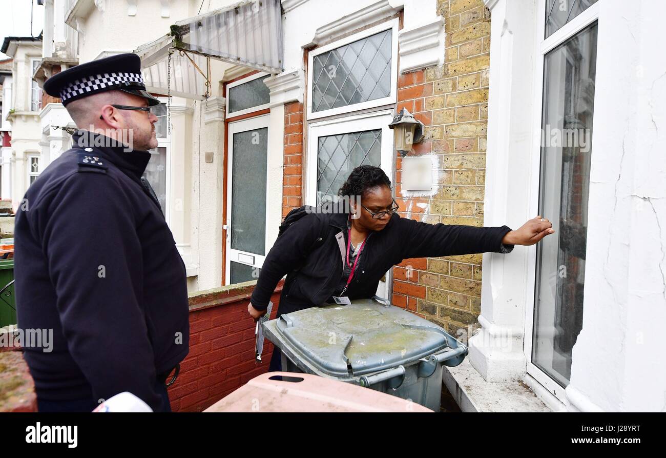Police and a council enforcement officer conducting a raid at a property in Newham, east London, ahead of an announcement by Mayor of London Sadiq Khan about a crackdown on unscrupulous landlords in the private rental sector. Stock Photo