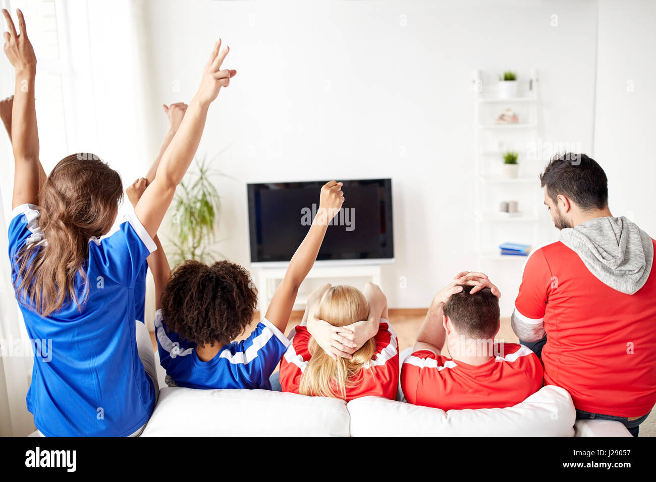 friends or football fans watching tv at home Stock Photo