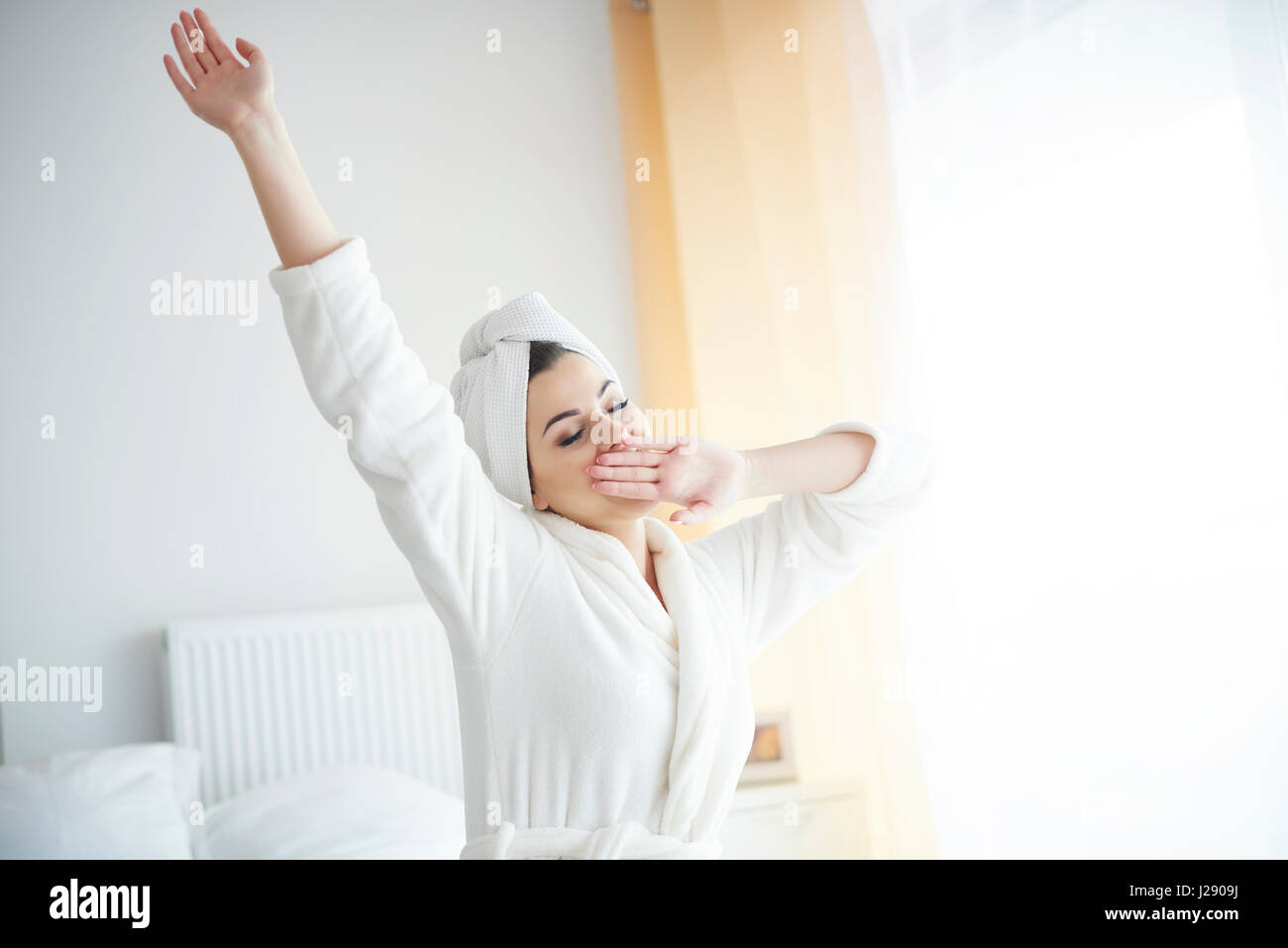 Young woman yawning and stretching Stock Photo