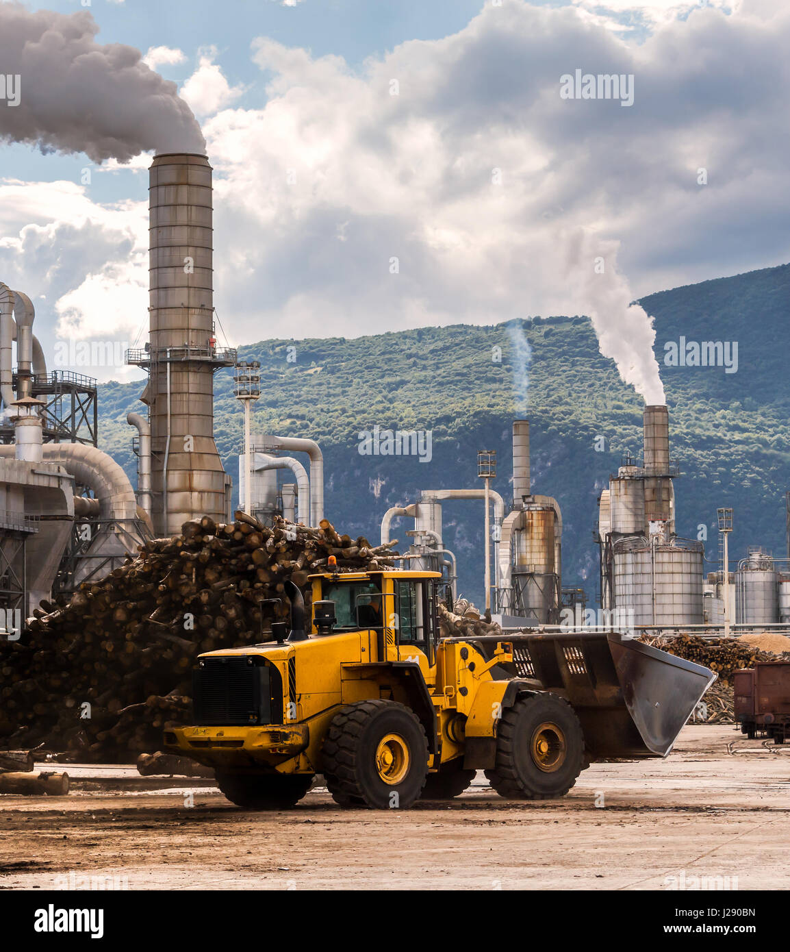 Industrial scene. Excavator ,smokestack,silos and rail wagon of lumber factory. Stock Photo