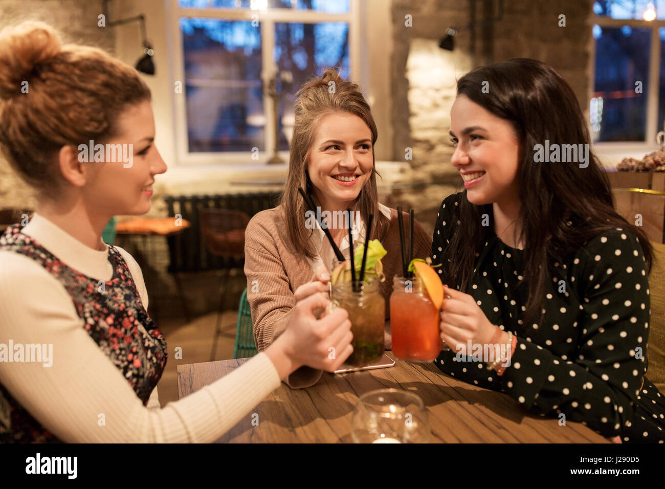 happy friends clinking drinks at restaurant Stock Photo