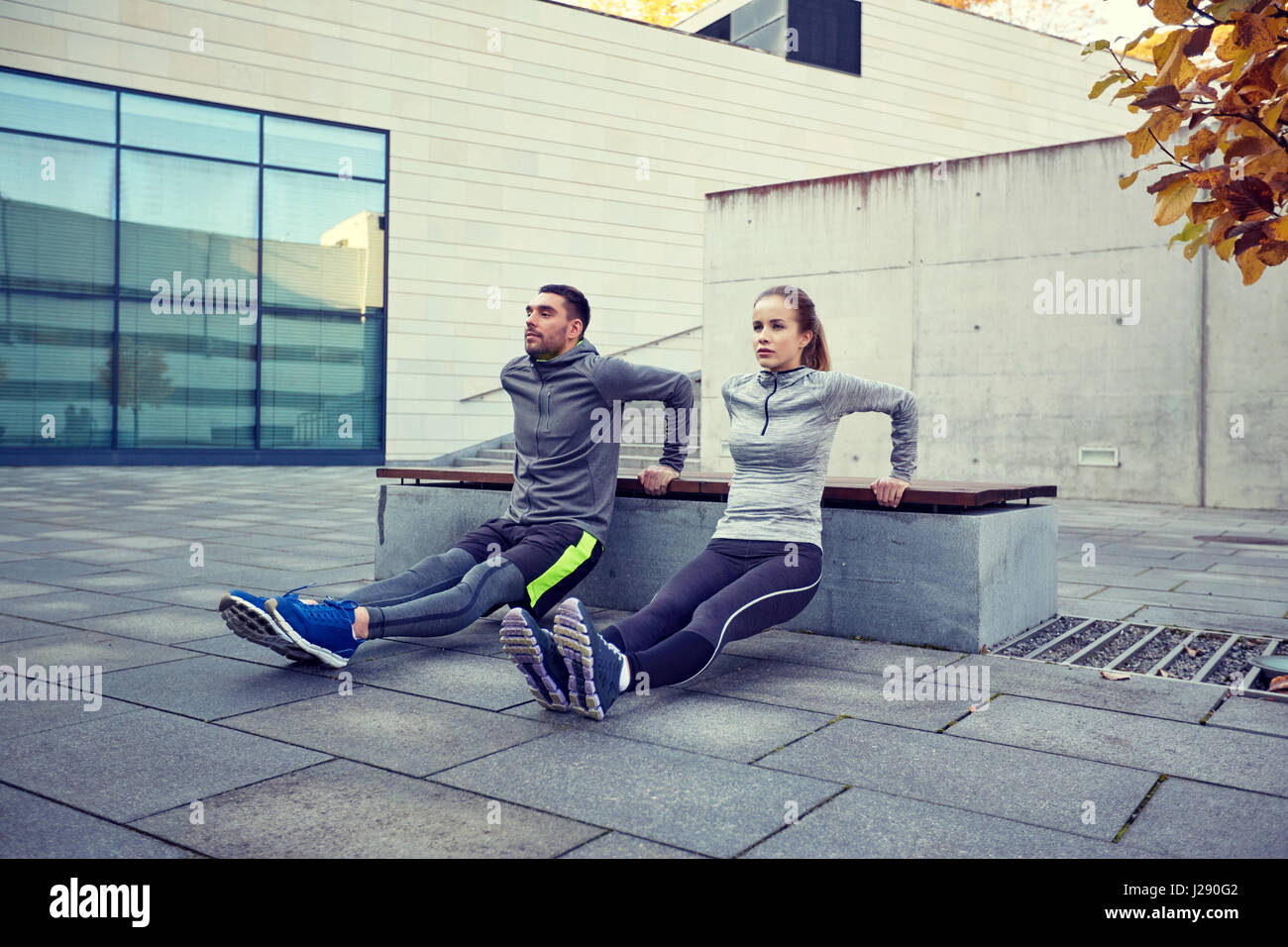 couple doing triceps dip exercise outdoors Stock Photo