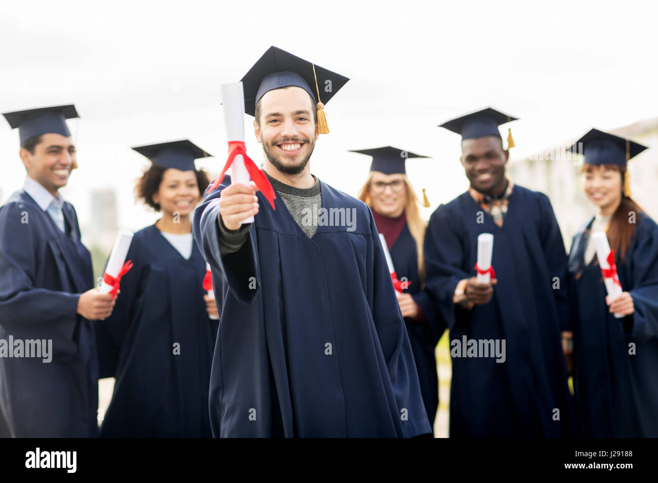 happy students in mortar boards with diplomas Stock Photo - Alamy