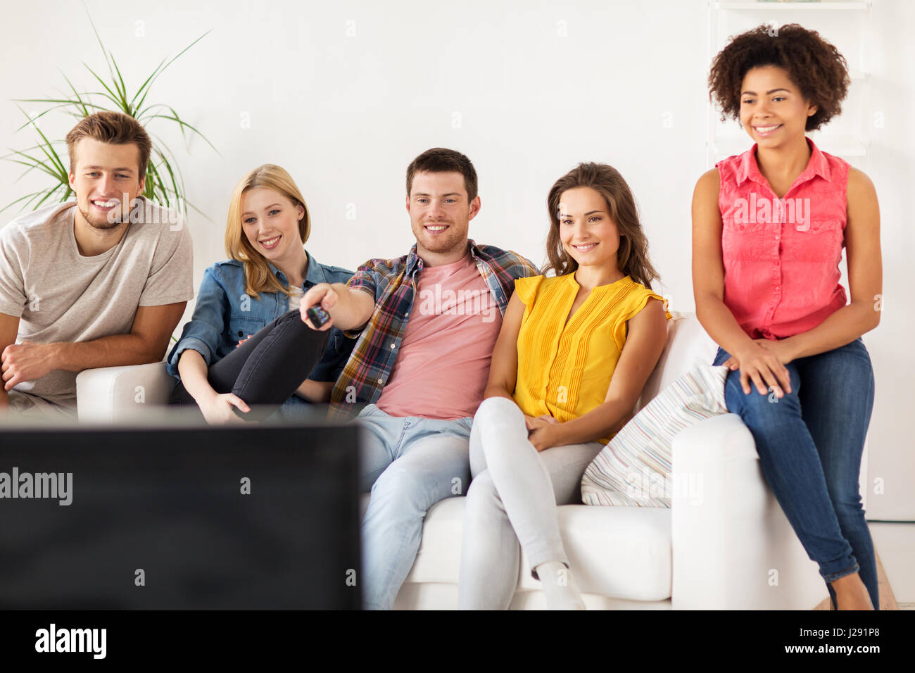 happy friends with remote watching tv at home Stock Photo - Alamy