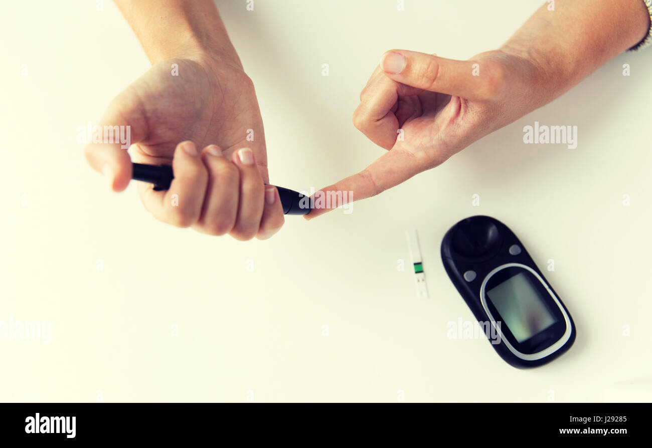 close up of woman making blood test by glucometer Stock Photo