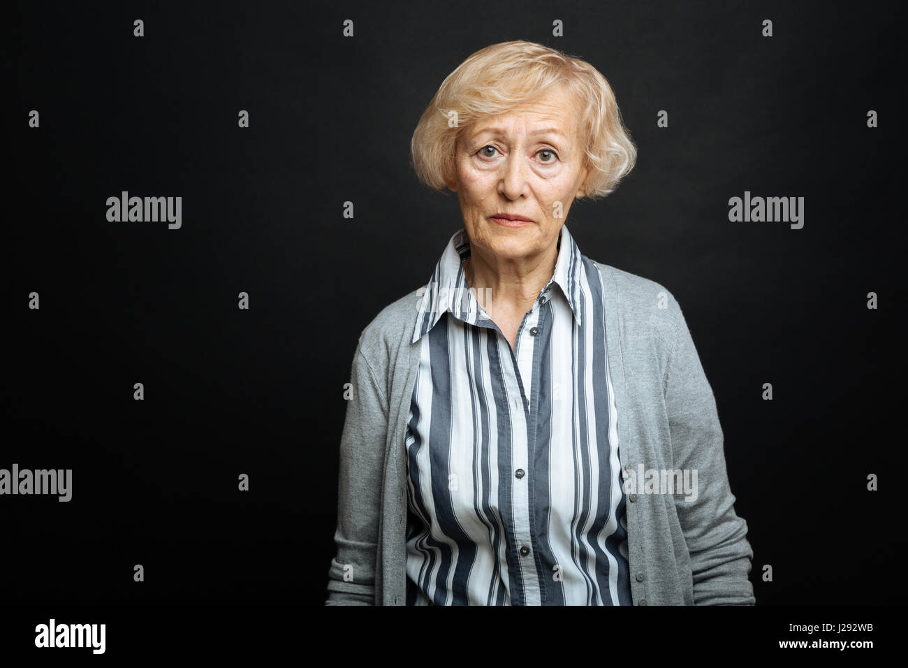 Pitiful aging woman demonstrating comparison indoors Stock Photo