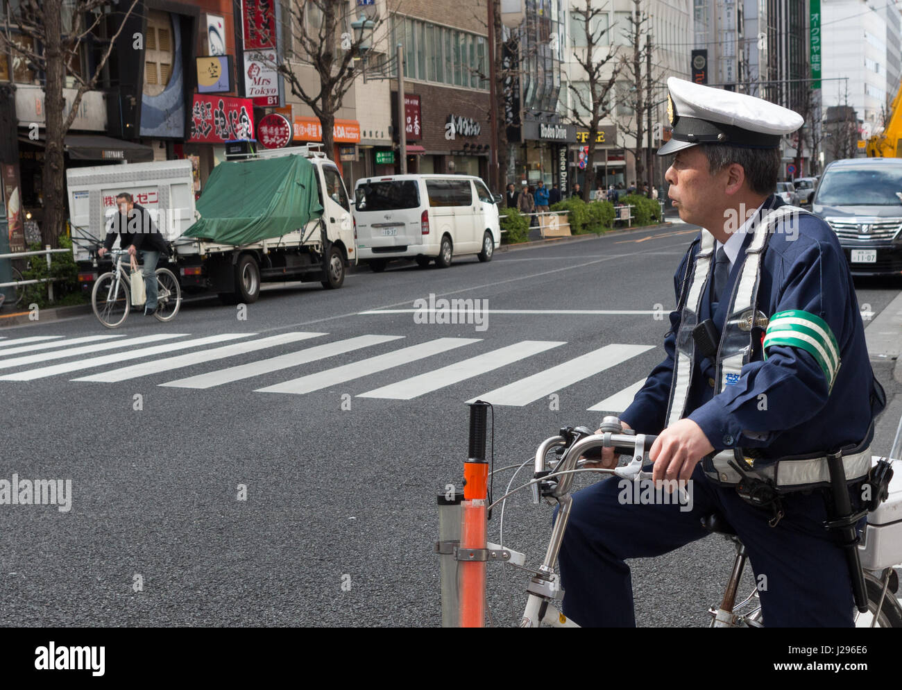 Tokyo, Japan - April 8th, 2017: Japanese policeman sitting on a bicycle in Tokyo, Japan. Stock Photo