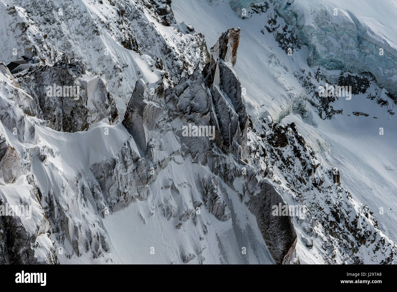 Detail of snow and ice covered cliffs and rockfaces on glacial mountain side off the side of the Mont Blanc in winter Stock Photo