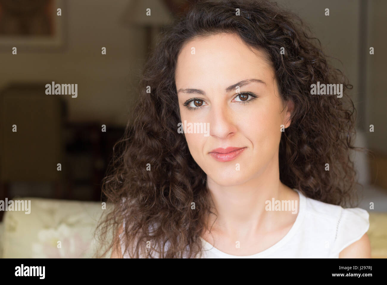 Portrait of a woman of 31 years old looking at camera in a confident way, curly and long hair, caucasian, greek. Stock Photo