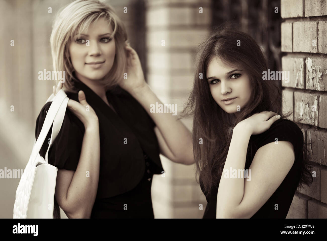 Two young women walking on a city street Stock Photo - Alamy