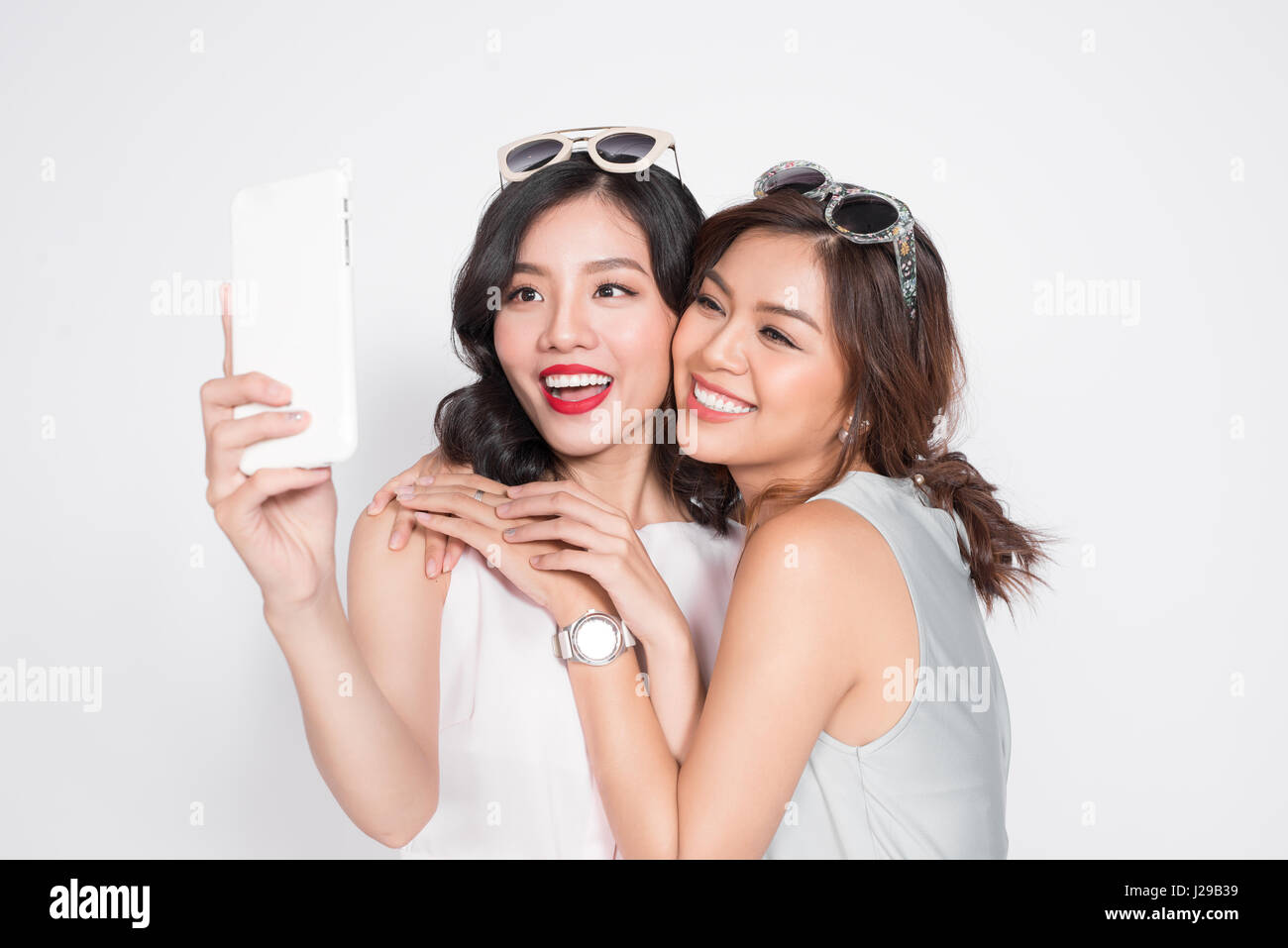 Portrait of two beautiful asian fashionable women taking selfie Stock Photo