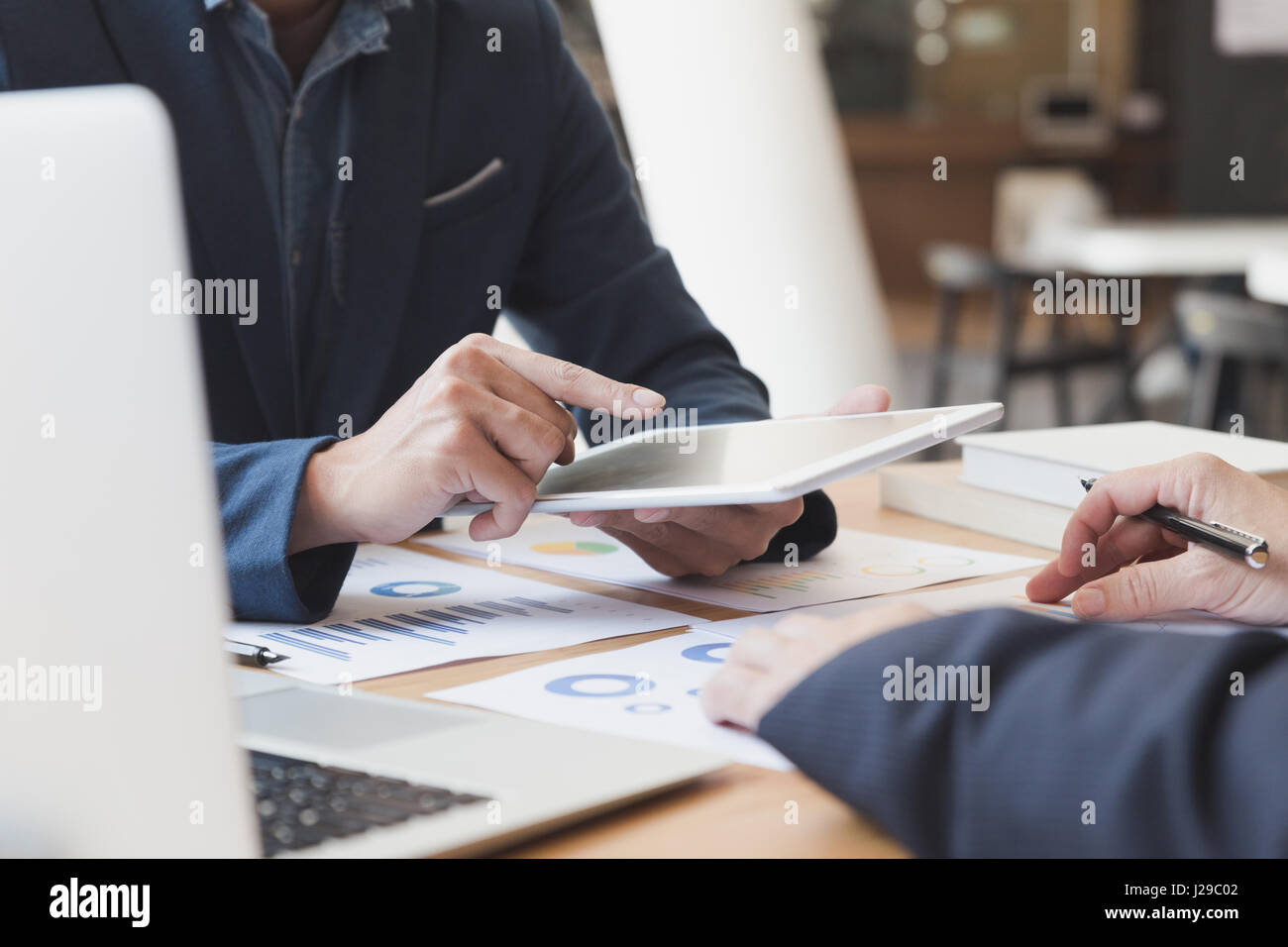 Businessman discussing with financial analyst business development strategy project chart document and using modern digital tablet touchpad Stock Photo