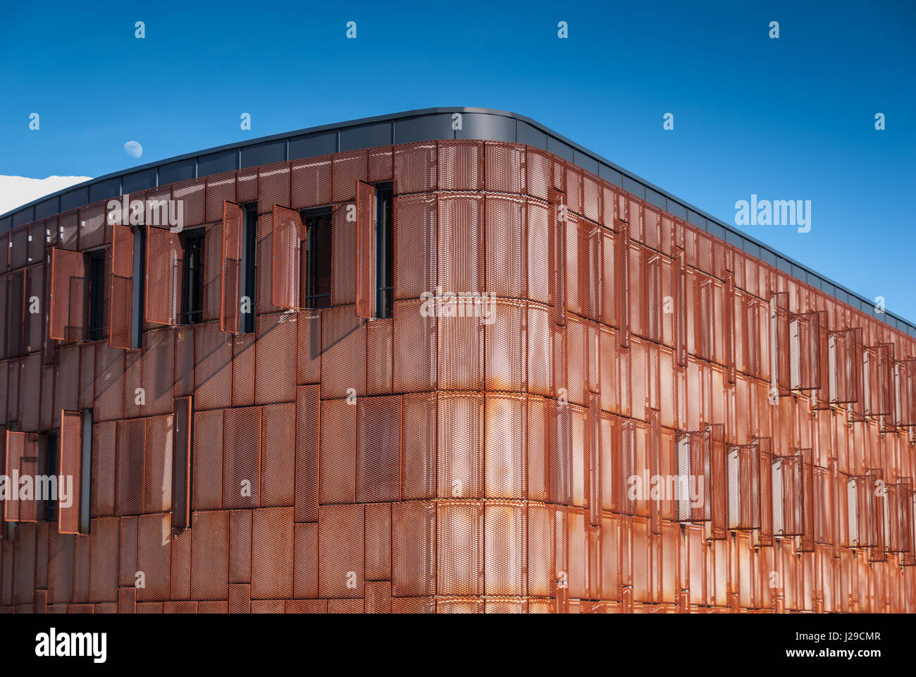Modern facade building with rusted steel expanded metal mesh panels with  open window shutters and deep blue sky in the background Stock Photo - Alamy