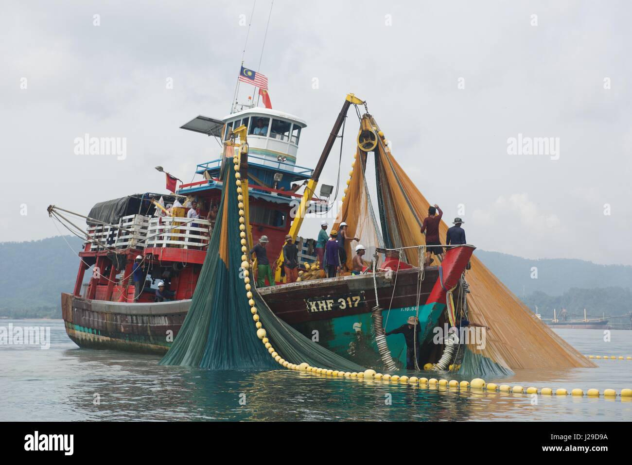 Fishing boat off the coast of Langkawi in Malaysia with nets out trawling the sea for their catch Stock Photo