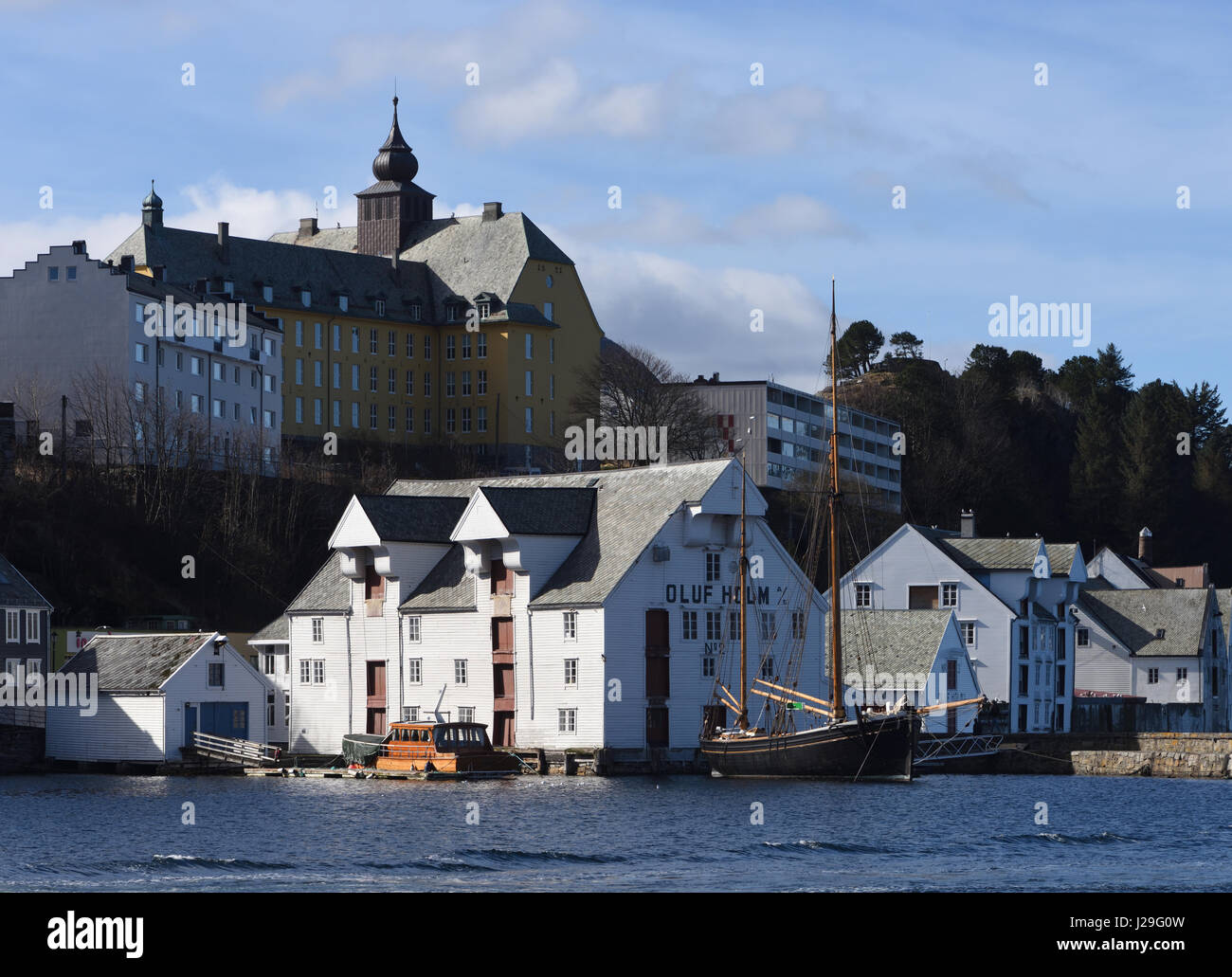 The Aspøy School, Aspøy skole, primary school with its tower and dome sits above the entrance to the harbour, the Brosundte,  of the port of Ålesund. Stock Photo
