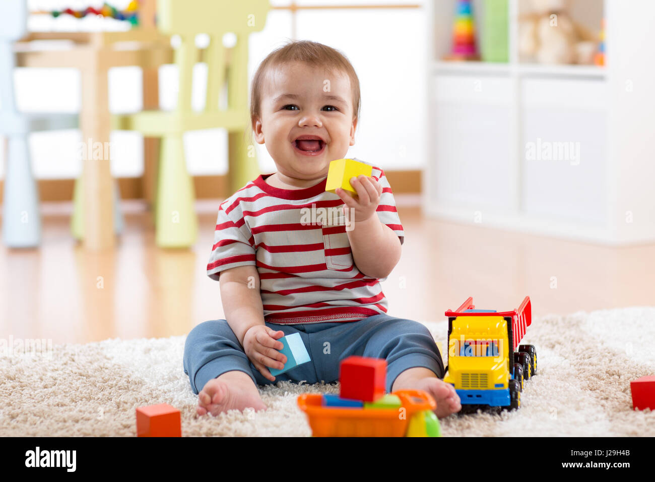 baby boy playing with his colorful toys Stock Photo - Alamy