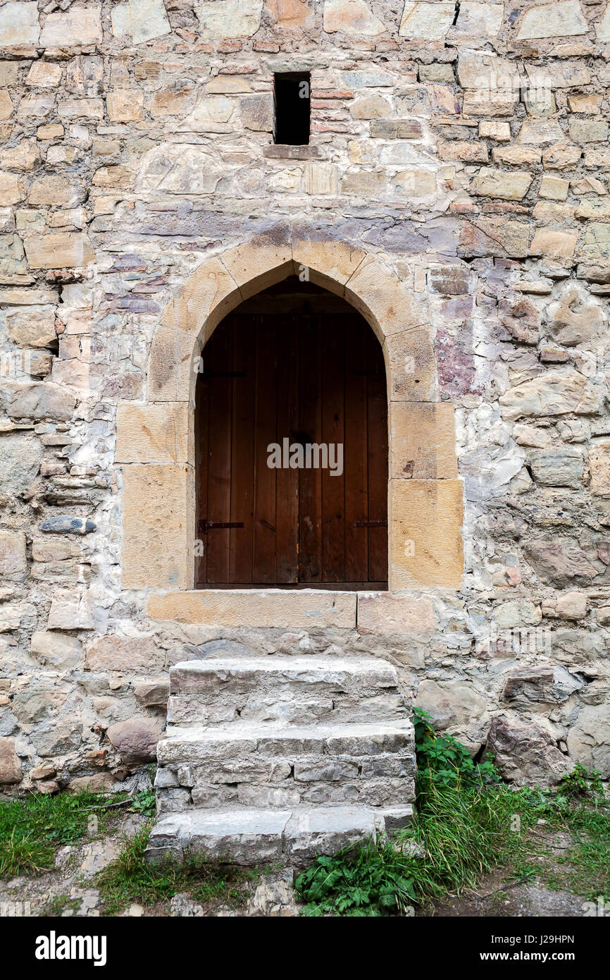 Old stairs and wooden door in a stone wall Stock Photo - Alamy