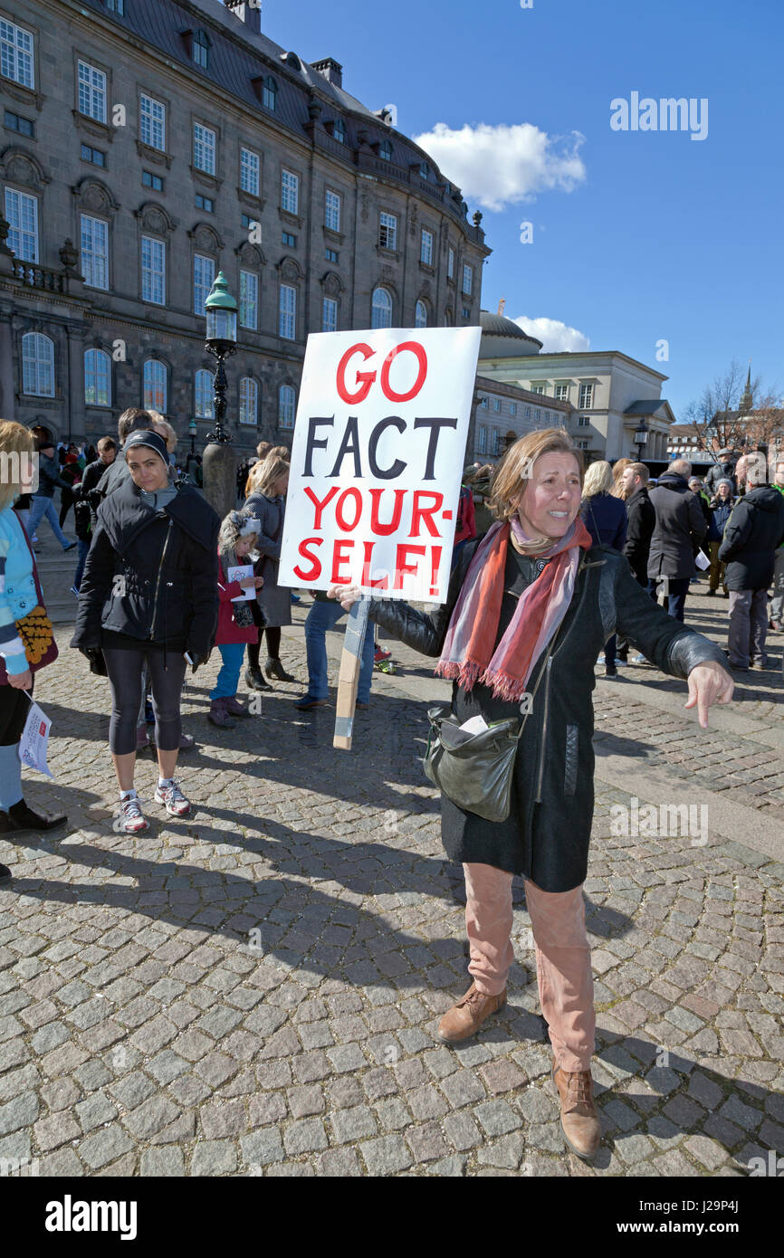 Woman holding GO FACT YOURSELF placard in Christiansborg Castle Square in Copenhagen after the March for Science now awaiting speeches / entertainment Stock Photo