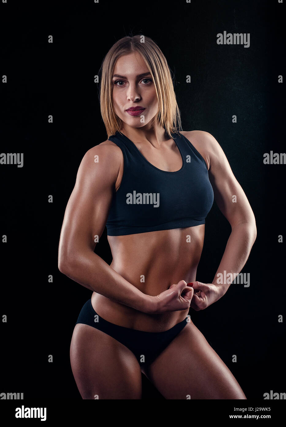 Sporty girl with great muscles in black sportswear. Tanned young athletic  woman. A great sport female body. Muscular build female after workout Stock  Photo - Alamy