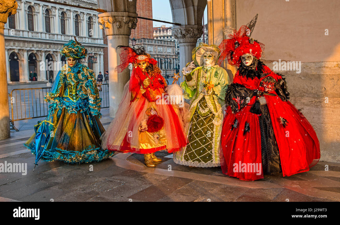 Four women in costume during the Carnival festival in St. Mark's Square in front of the Palace of the Doges in Venice, Italy. Stock Photo