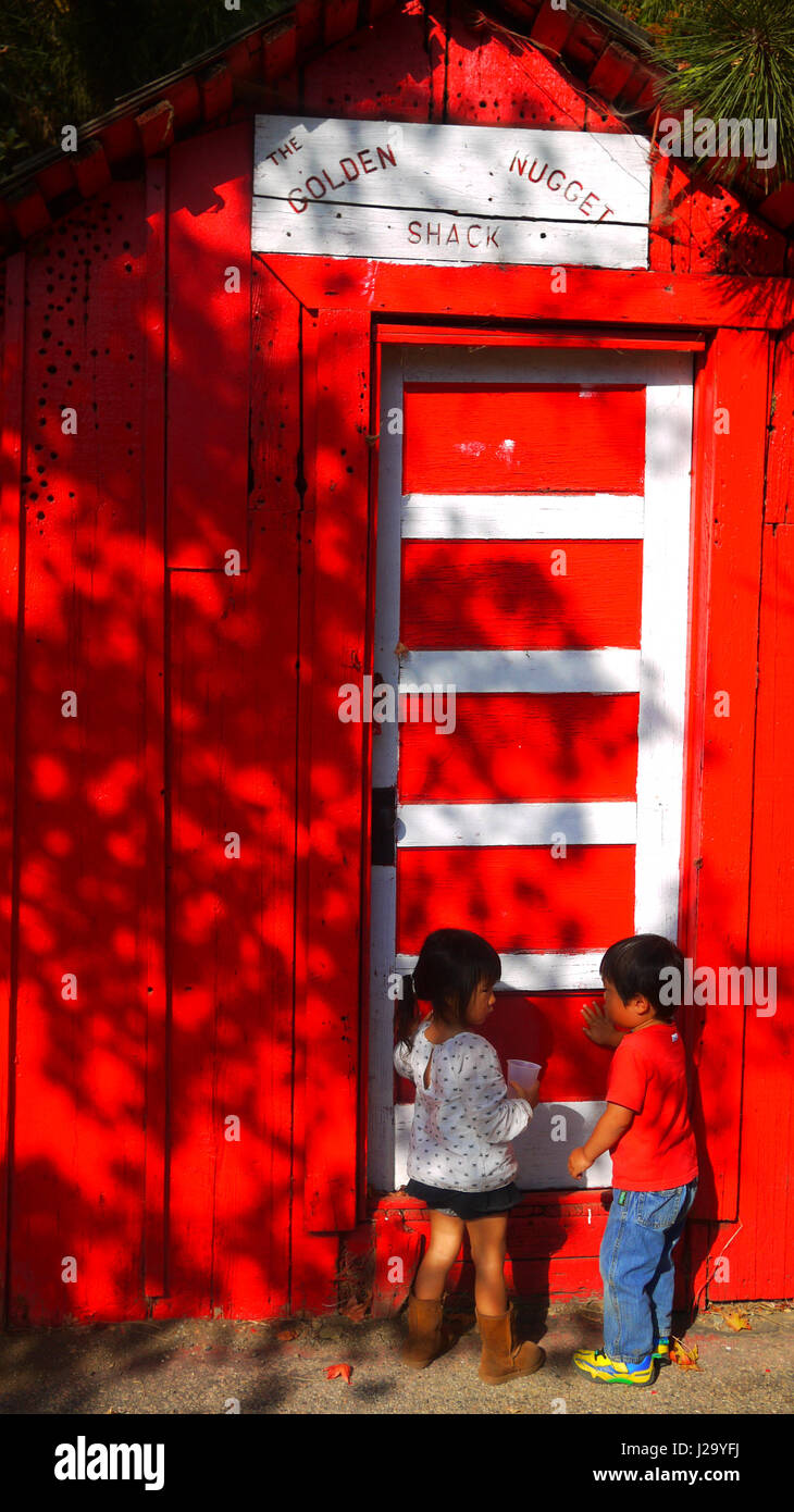 child boy girl talking red wall couple Stock Photo