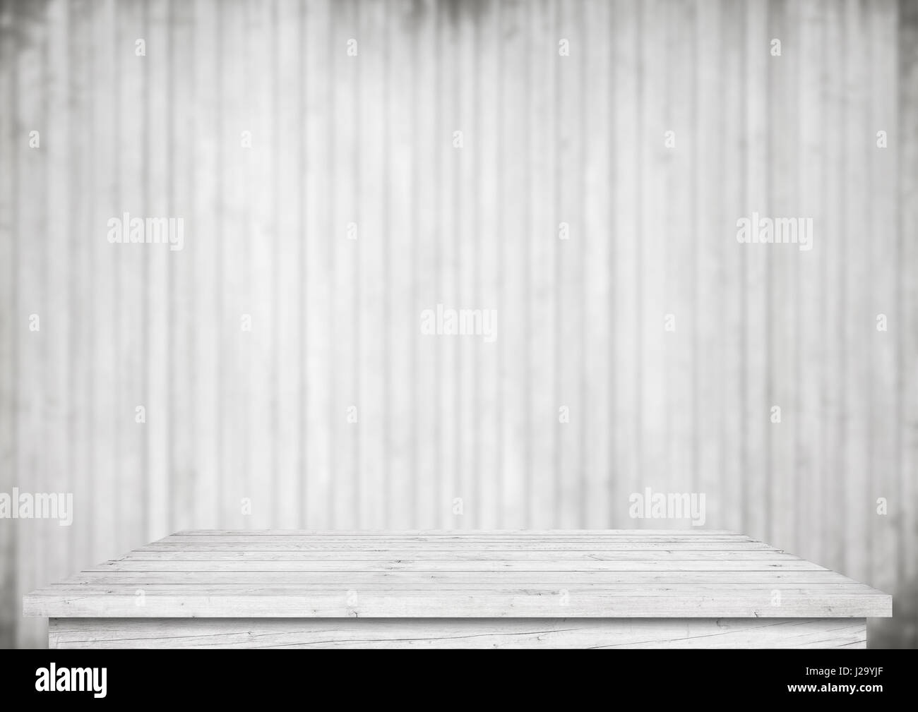 Empty white table next to blurred wooden wall Stock Photo