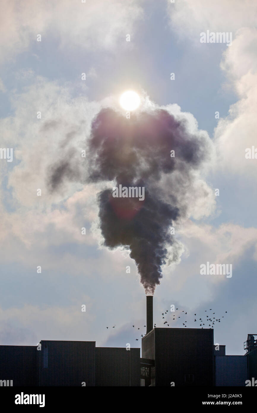 Concept Photo Industrial emissions on a partly clouded day. Stock Photo