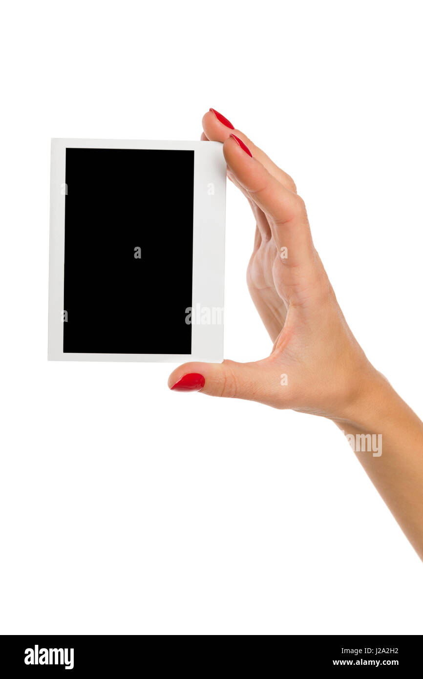 Close up of woman's hand with red nails holding blank polariod photo. Studio shot on isolated on white. Stock Photo