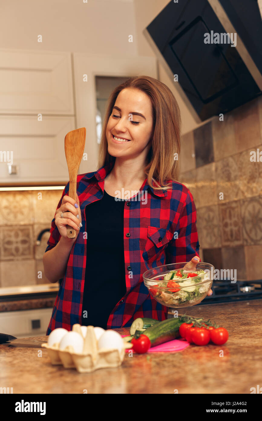 Cheerful young woman is cooking in the kitchen with joy Stock Photo Alamy